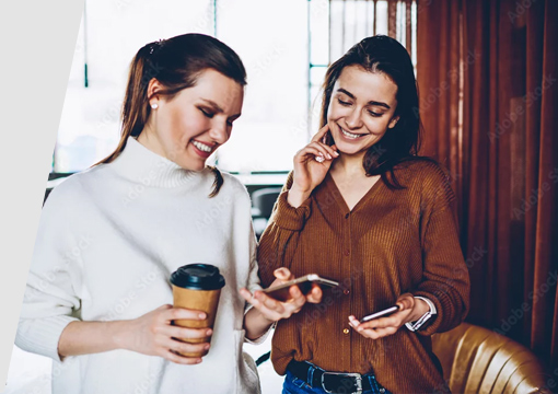 Two women on phones with coffee